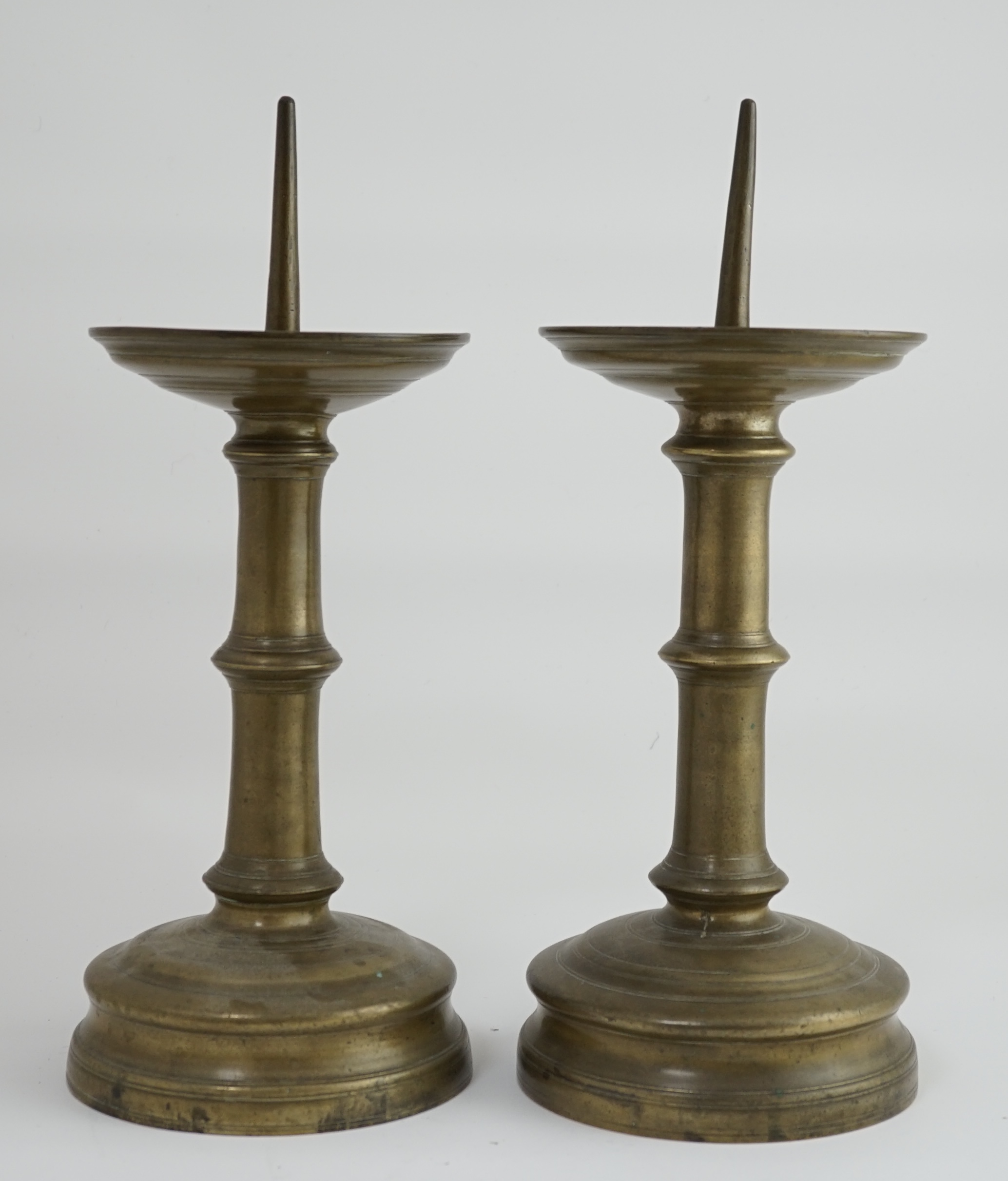 A pair of 16th century bell metal pricket candlesticks